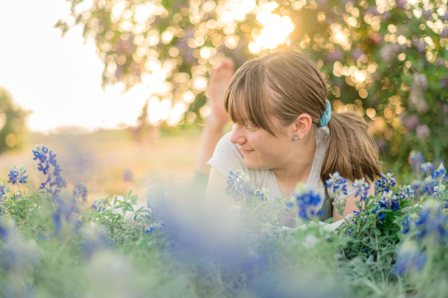 girl laying in bluebonnets