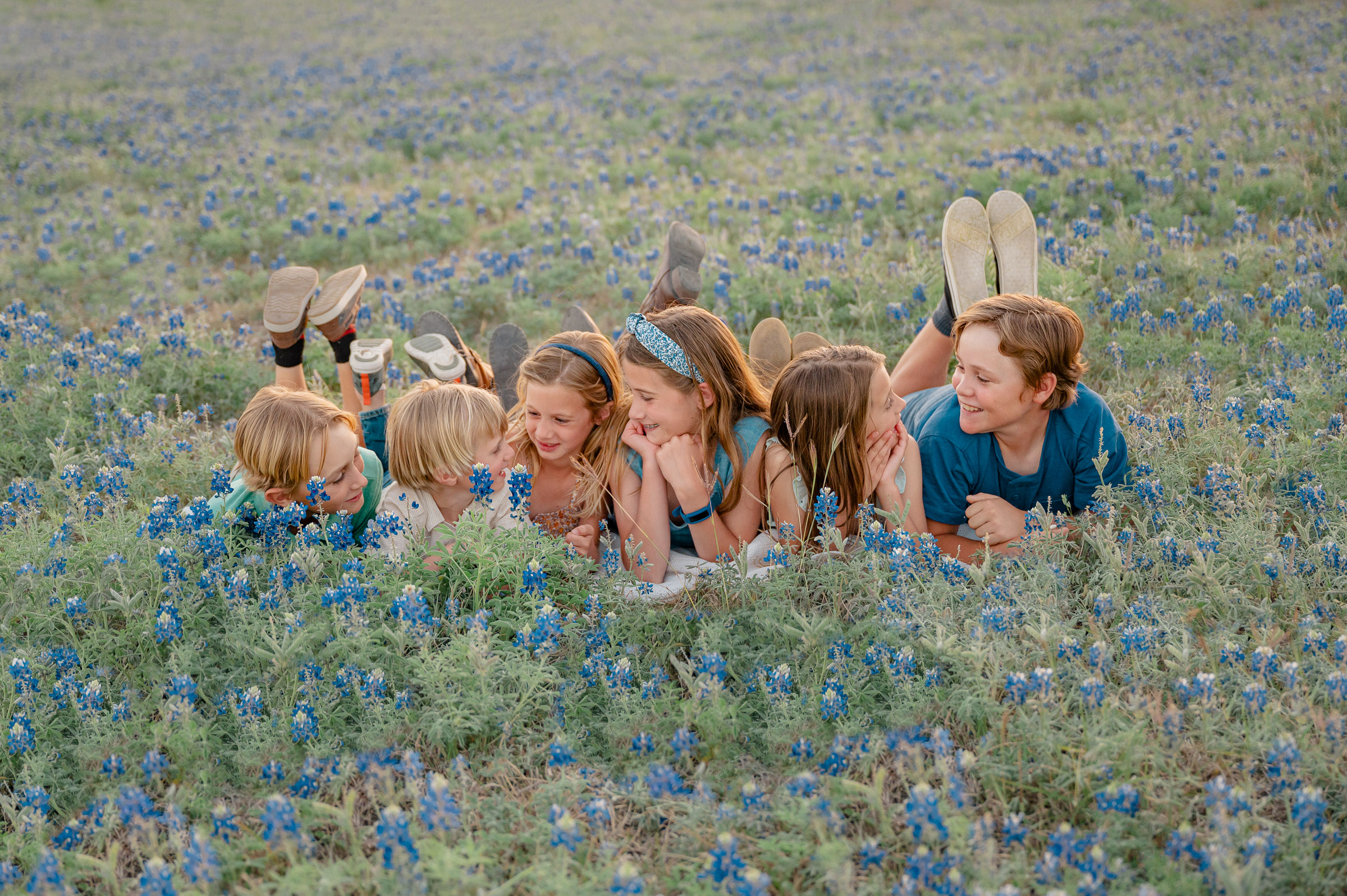 Six siblings talking together during San Antonio bluebonnet pictures with Cassey Golden Photography.