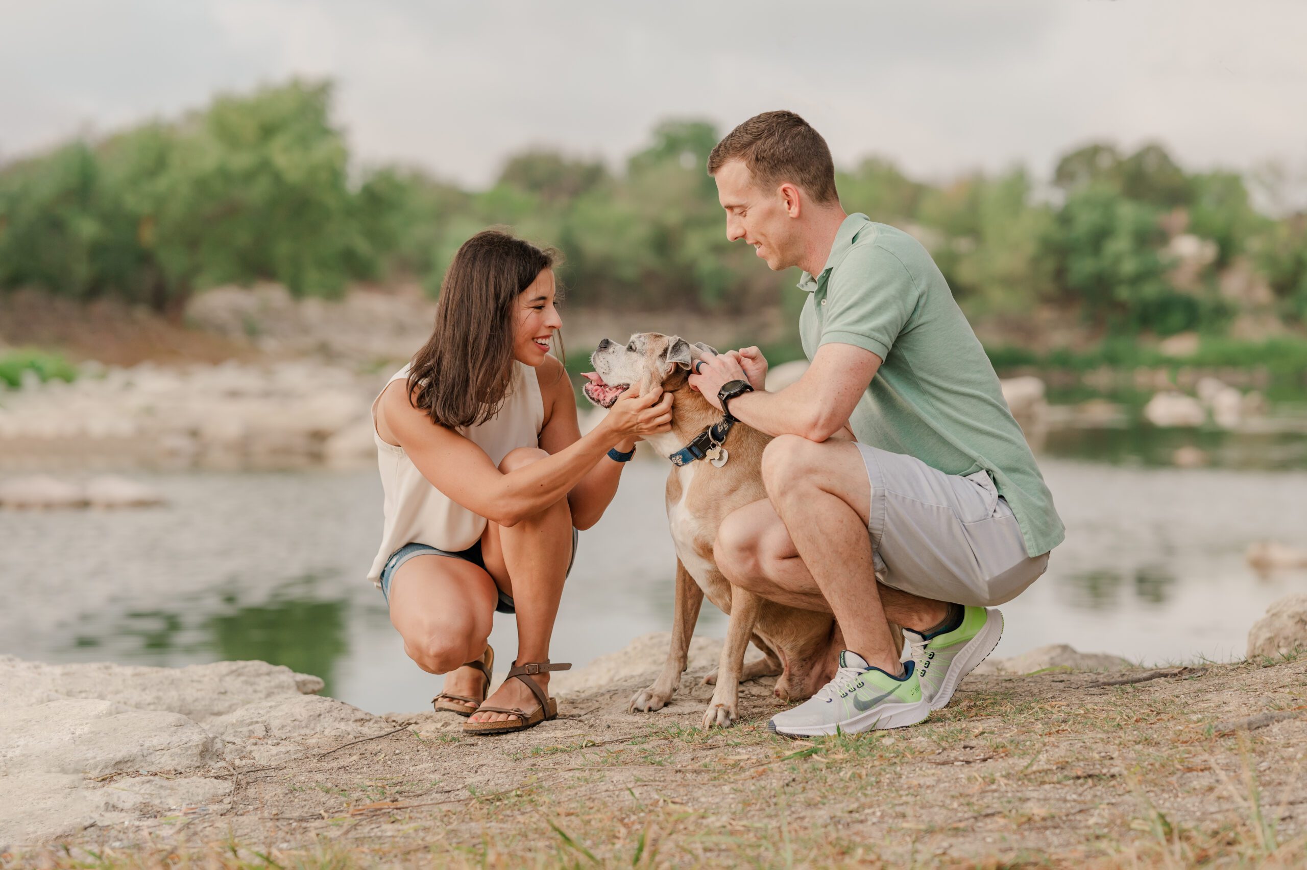 A couple pets their dog by the quarry at Tom Slick Park in San Antonio.