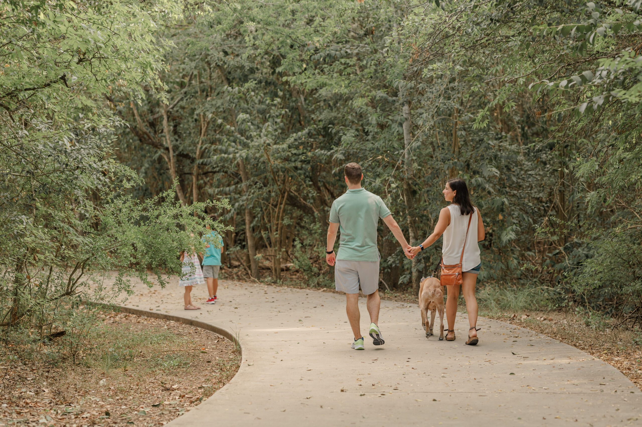 A family of four walks their dog on the trail that loops the quarry at Tom Slick Park in San Antonio. 