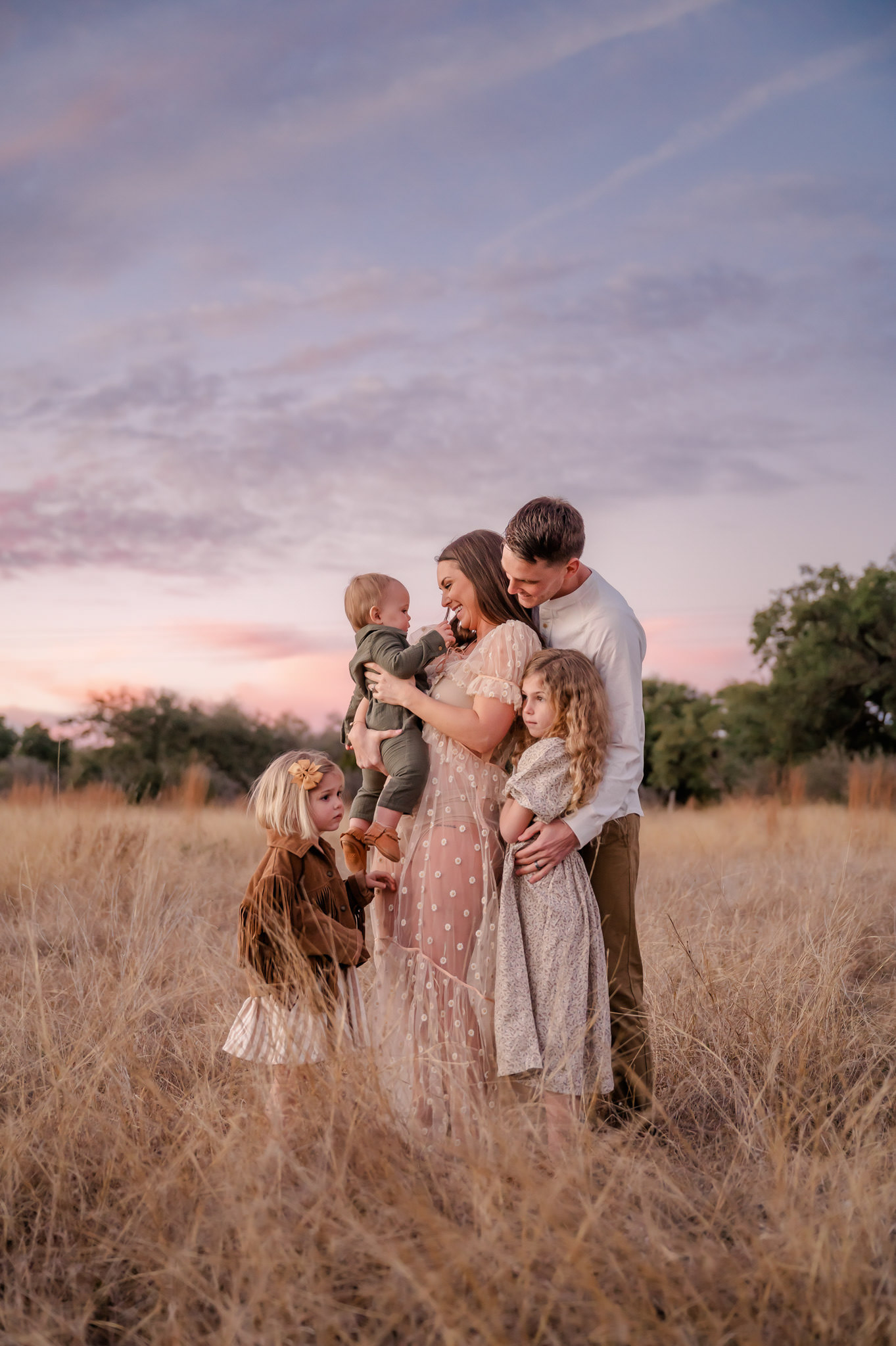 A family interacts at dusk at Joshua Springs Park and Preserve during family pictures with San Antonio family photographer Cassey Golden. 